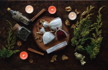 Yule winter solstice (Christmas) celebration themed magick spell bags filled with various herbs, spices, to put under the pillow for magickal night's sleep. Festive background with evergreen branches