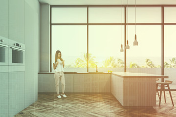 Panoramic kitchen with bar and ovens, woman