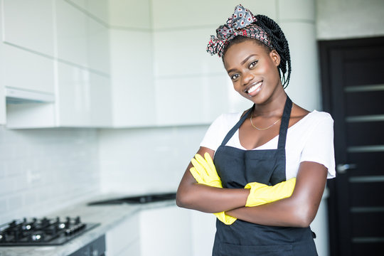 Premium Photo  Positive african american maid cleaning kitchen and smiling