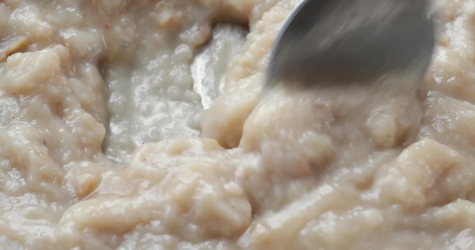 Close video of stirring then taking a spoonful of fish chowder in a pan while cooking.