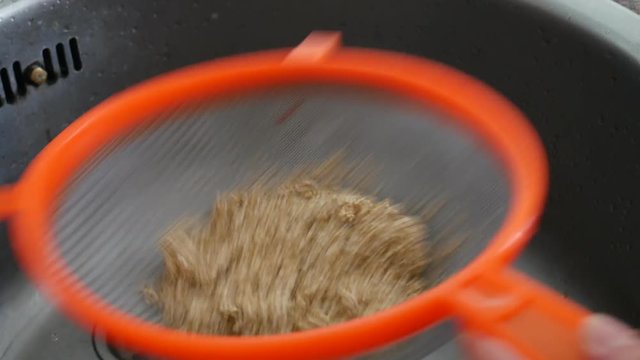 Young woman washing quinoa, quinua recipe 
