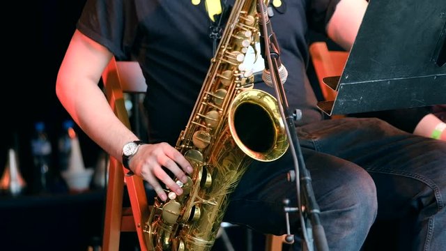Musician playing saxophone at live concert on the stage