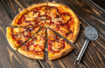 pizza on wooden table with ingredients, tomatoes, pepper, onion
