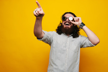 Happy bearded hipster man pointing up