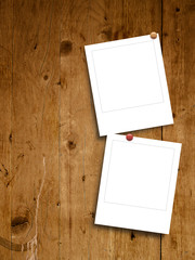 Two blank instant photo frames on brown wooden background