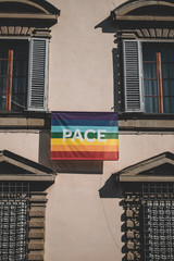 An LGBT flag hanging out of a window in Italy Bologna