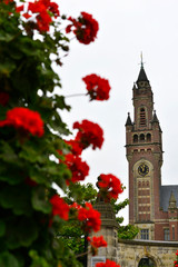 Tower of the Peace Palace in the background of red flowers.