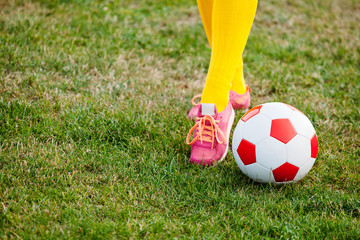 Feet of girl on football field with ball close up