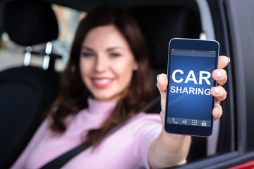 Woman Sitting Inside Car Showing Car Sharing App On Smartphone