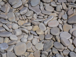 Full-frame image of slightly lavender colored rounded rocks piled on a beach