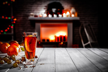 A winter composition on a wooden table in the glow of a fireplace and a Christmas tree decoration on a magical evening   