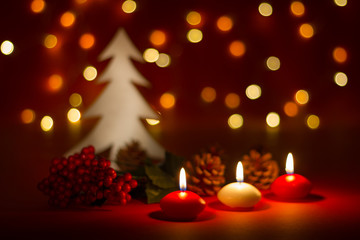 Fototapeta na wymiar Christmas candles and ornaments over dark background with lights