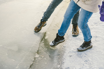 Trying the danger of the foot, testing the thin ice near the shore. A pair of lovers walk with a...