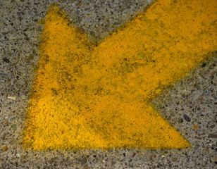 Yellow arrow on the concrete surface