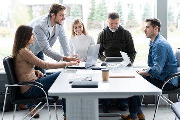 Sharing opinions. Group of young modern people in smart casual wear discussing business while working in the creative office.