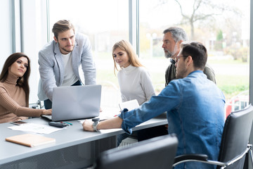Sharing opinions. Group of young modern people in smart casual wear discussing business while working in the creative office.