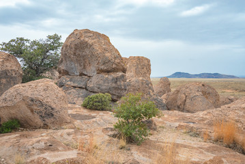Arid landscape with huge boulders and trees on a cloudy day