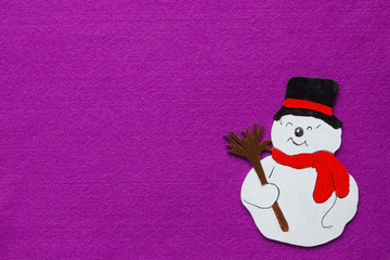 Schneemann mit Besn nd Zylinder,Ornament aus bemaltem Holz auf Hintergrund aus violettem Filz mit grossem Textfeld