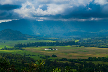 Obraz premium Aerial view overlooking a tropical valley with the sun streaking through the clouds on the island of Kauai, Hawaii, USA