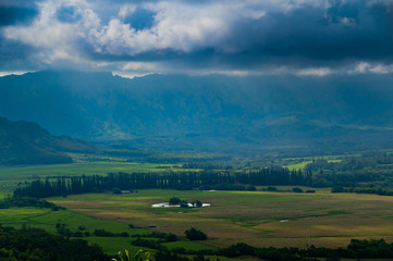 Aerial view overlooking a tropical valley with the sun streaking through the clouds on the island of Kauai, Hawaii, USA