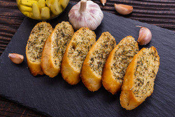 fragrant garlic bread on a dark stone plate