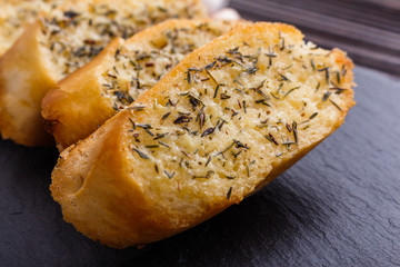 fragrant garlic bread on a dark stone plate