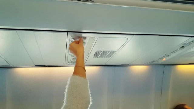 Girl regulates the flow of air in the plane, air conditioning