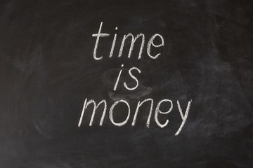 Obraz premium Hand writing Time is Money on a blackboard.