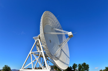 Array of satellite dishes or radio antennas against sky. Space o