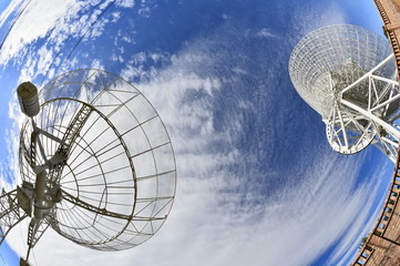 Array of satellite dishes or radio antennas against sky. Space observatory.