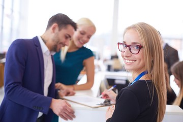 Obraz premium Sales situation in a car dealership, the young couple is signing the sales contract to get the new car