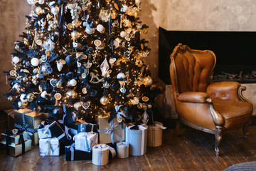 Interior of cozy loft room decorated in Christmas Happy new Year style. No people. Christmas tree with presents under it. Selective focus. Happy NY mood.