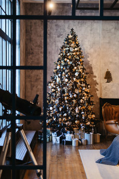 Interior Of Cozy Loft Room Decorated In Christmas Happy New Year Style. No People. Christmas Tree With Presents Under It. Selective Focus. Happy NY Mood.