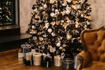 Merry Christmas and Happy New year Holidays! Decorating the Christmas tree indoors. Macro or close picture of xmas tree and gifts under it. Gift box background for 2019 new year gift card