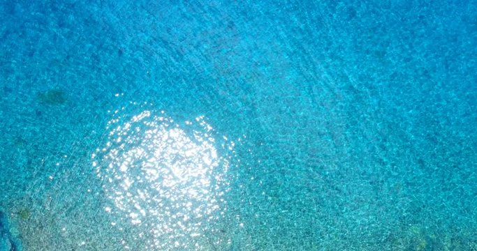 Ocean sea with Sparkling light reflections on sea. Aerial drone video of Stunning sunlight glittering on turquoise water. Amazing sun sparkles on ocean water during sunny day.
