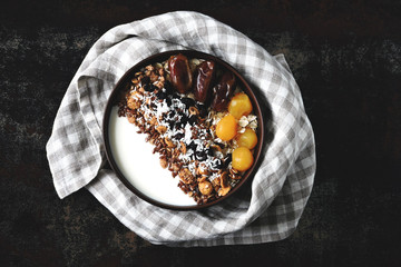 Breakfast bowl with greek yogurt, granola and dried fruit. Healthy colorful food. Top view.