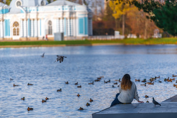 Lonely lady sitting by the lake with the Grotto in the background, Pushkin, Tsarskoe Selo, St...