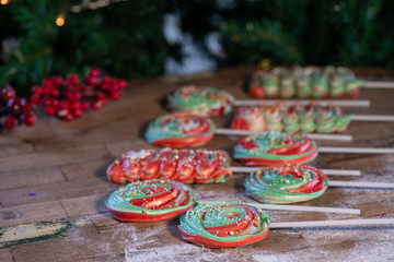 Various Christmas sweets and candies with christmas tree on wood table