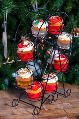 Various colorful Christmas cupcakes with christmas tree on wood table