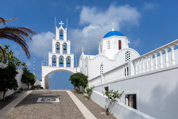 Very beautiful Orthodox church in the city of Karterados on the island of Santorini. Typical white church on Santorini. Photo of a greek church in Santorini and the blue sky