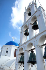 Fototapeta na wymiar Very beautiful Orthodox church in the city of Karterados on the island of Santorini. Typical white church on Santorini. Photo of a greek church in Santorini and the blue sky
