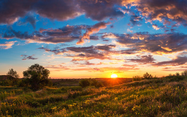 Summer bright landscape. Cloudy sunset over the steppe hills. Cloudy sky and sunlight. Ukrainian...