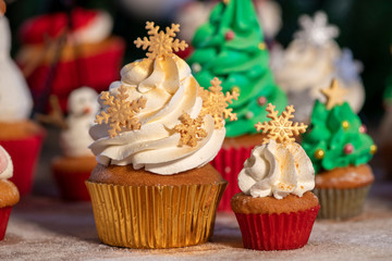 Various colorful Christmas cupcakes with christmas tree on wood table