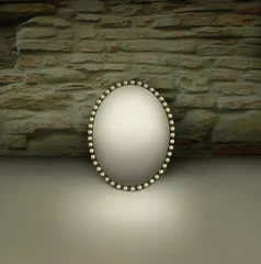 Fototapete Surrealismus Kleiner Spiegel mit Vintage-Rahmen verziert mit Perlen auf einem Boden und mit Backsteinmauer-Hintergrund