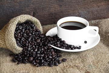 Coffee cup with coffee beans on burlap bag