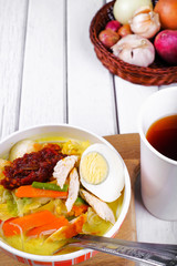 Lontong-Traditional Malaysian and   Indonesian food on wooden table with spoon.