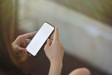 Cropped shot of female hand holding blank screen mobile phone