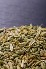 Essential oil of fennel seeds on a dark stone background