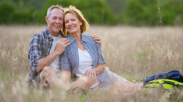 Portrait of active senior Caucasian American couple wearing casual clothing enjoying retirement sitting in the countryside outdoors 