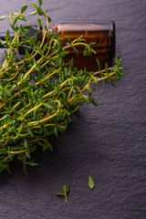 essential oil of thyme on a dark stone background